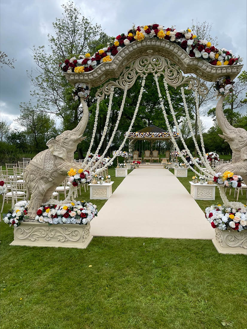 Indian wedding decorations for an outdoor wedding. Elephants and Flowers in an arch.